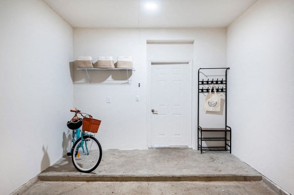 A bicycle is parked in a white hallway.