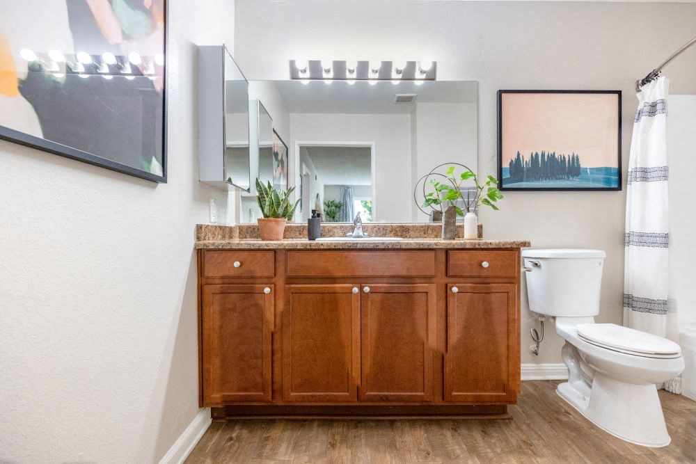 A bathroom with a wooden vanity and a white toilet.