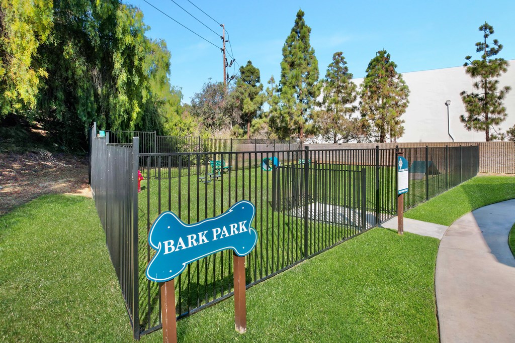 a fence with a sign that reads bark park