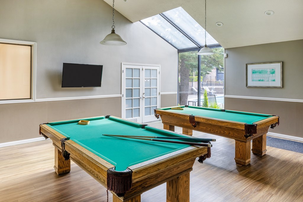 A room with a pool table and a television.