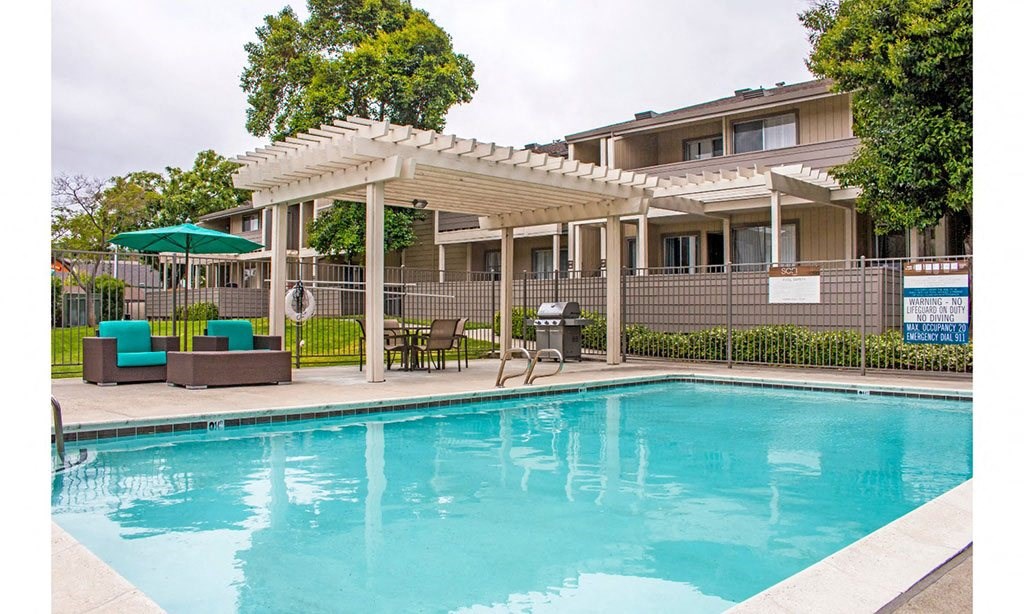 a swimming pool with a pergola next to a resort style pool