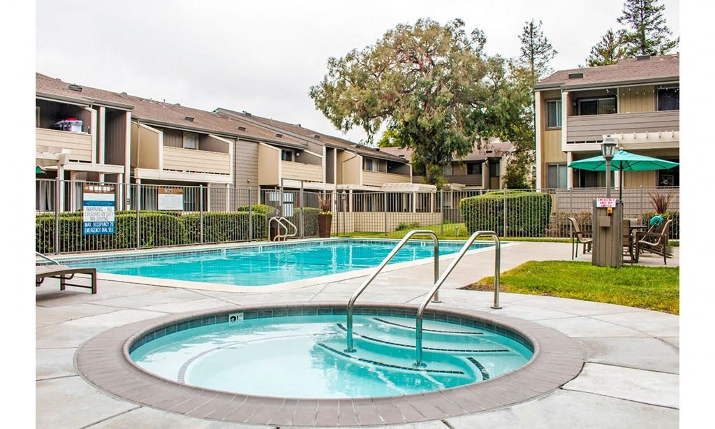 a swimming pool with an apartment building in the background