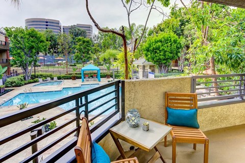 a balcony with a pool and a table and chairs