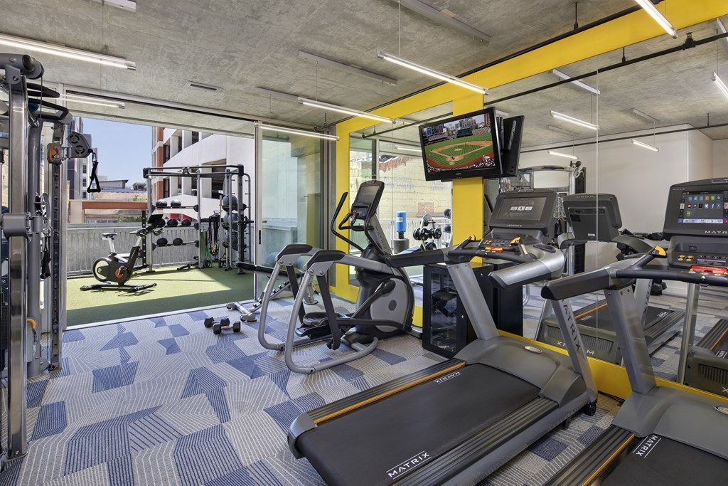 A gym with treadmills, weights, and exercise equipment.