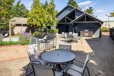 A patio with a table and chairs in front of a building.