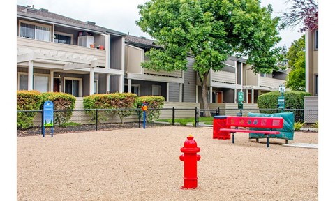 a red fire hydrant sitting in front of an apartment building
