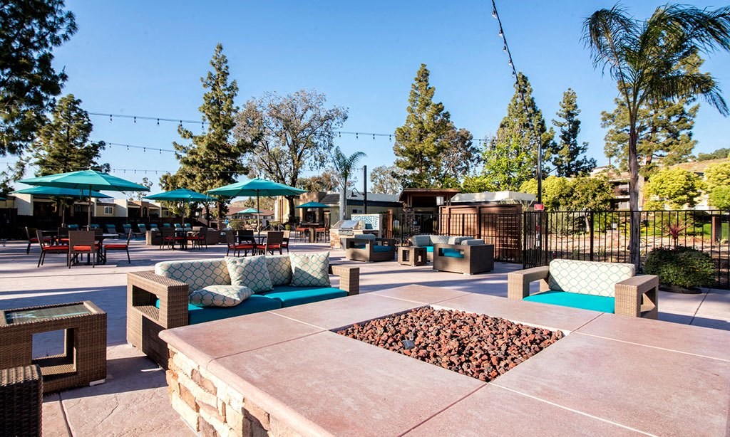 an outdoor patio with tables and chairs and fire pit