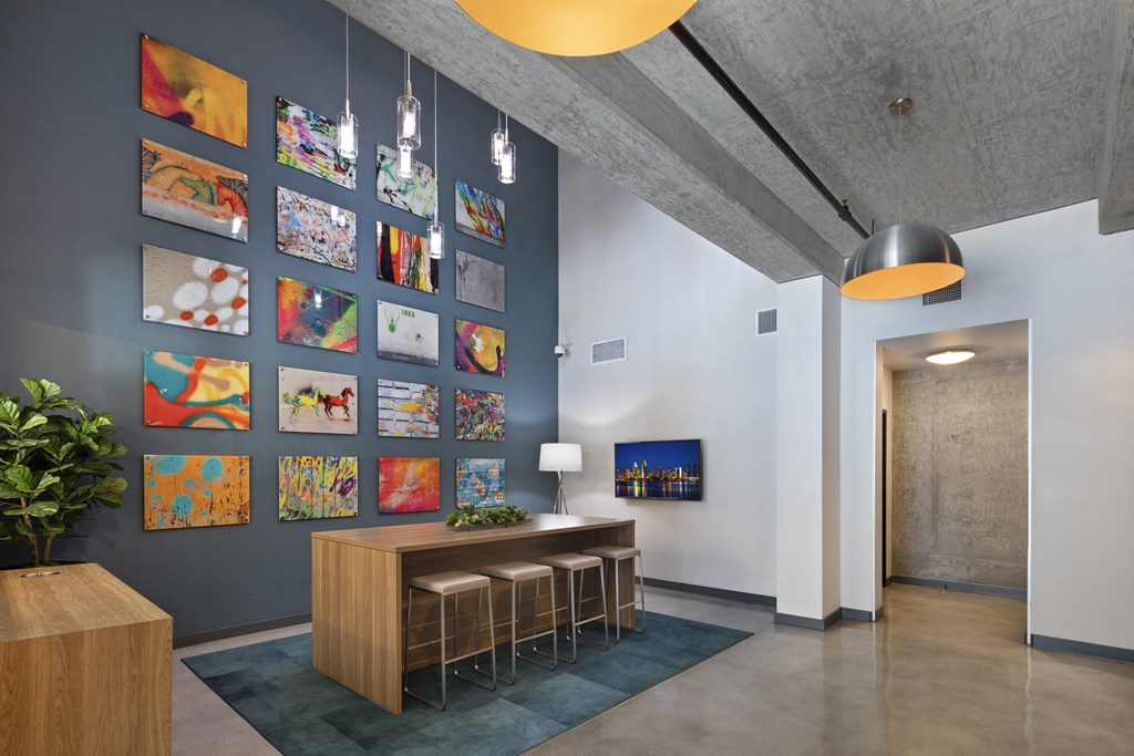 A room with a grey wall and a wooden table with stools.