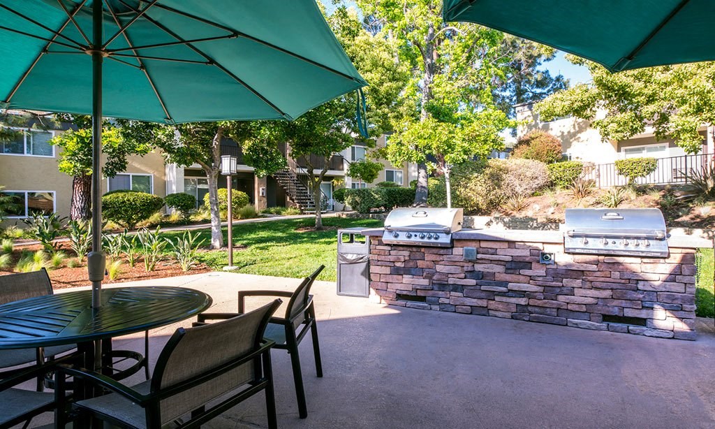 a patio with a table and chairs and a green umbrella