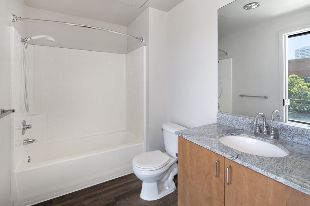 A white bathroom with a toilet, sink, and shower.