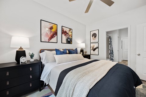 a bedroom with a bed and pictures on the wall
