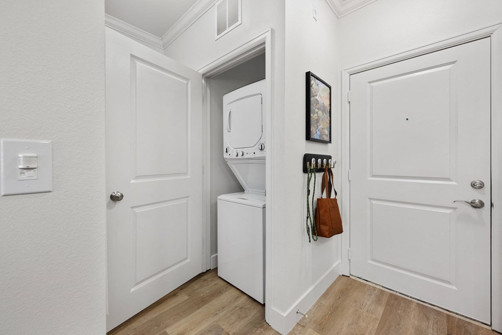 a laundry room with a washer and dryer and a door to the closet