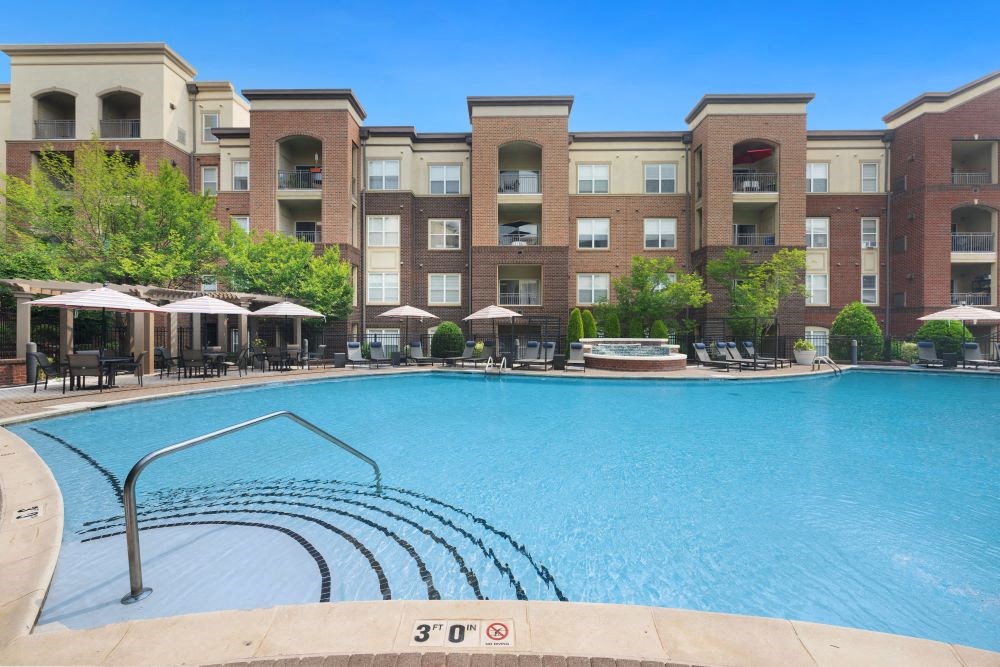 a swimming pool with an apartment building in the background