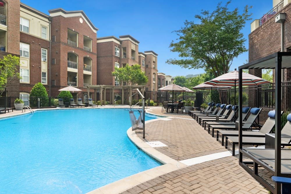 a swimming pool with lounge chairs and a building in the background