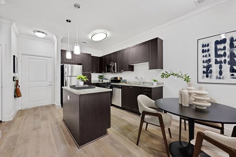 a kitchen and dining room with dark wood cabinets and a table and chairs