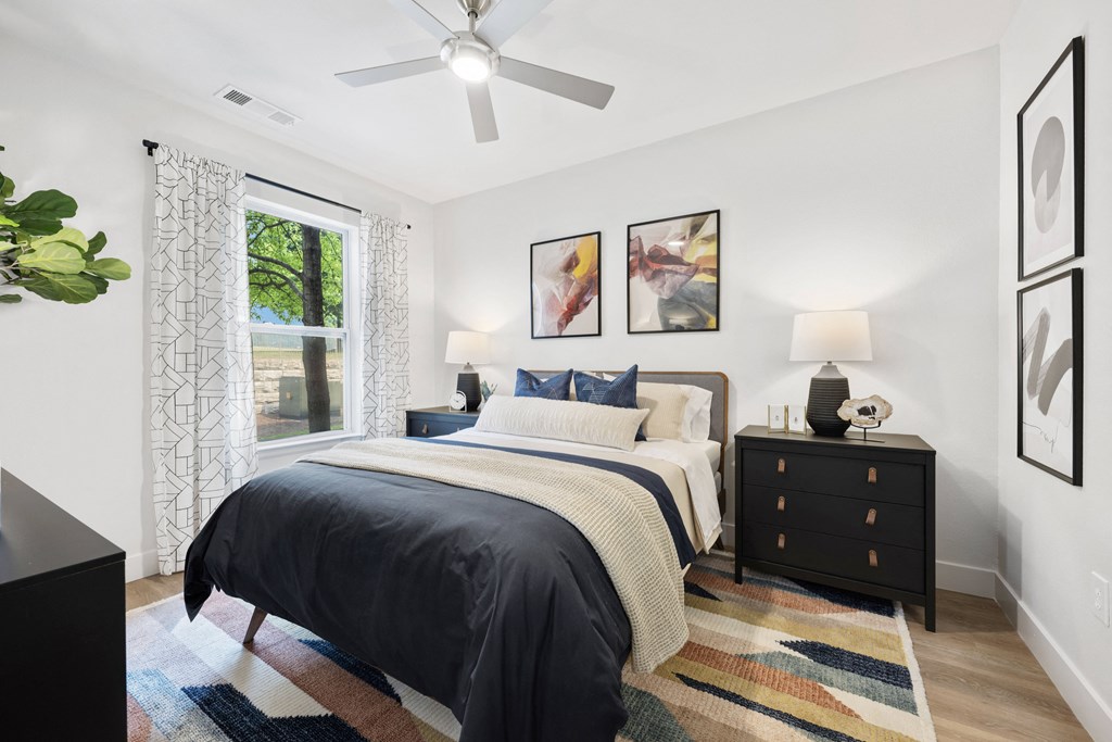 an open bedroom with a bed and a ceiling fan