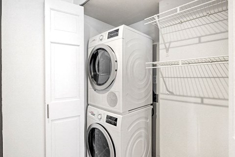 a white laundry room with a washing machine and a dryer