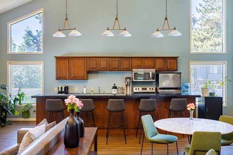 A kitchen with a table and chairs in front of a counter with a microwave and oven.