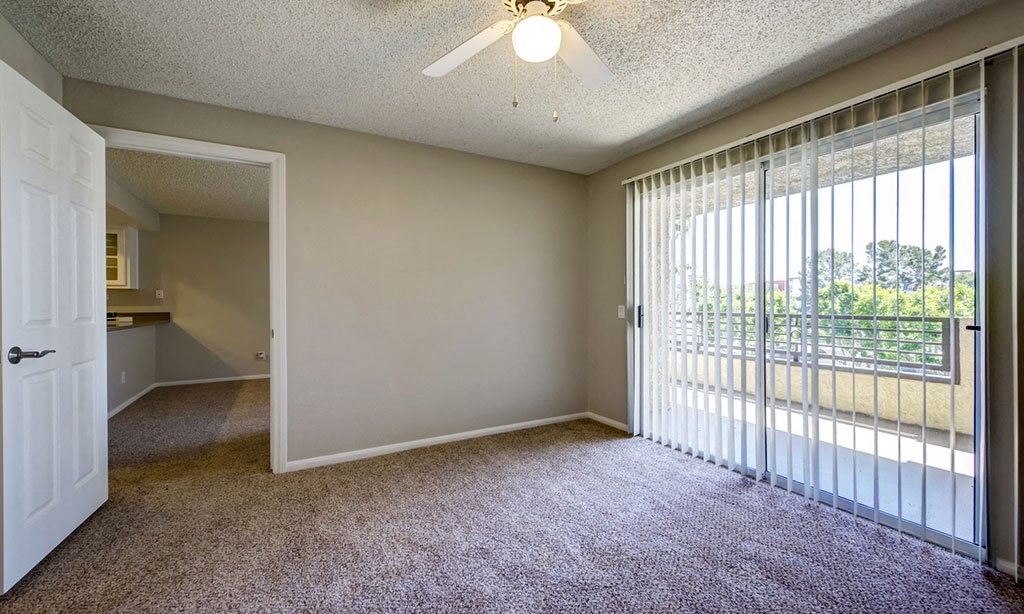 a living room with a large window and a sliding glass door