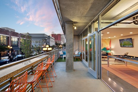 A patio with orange chairs and a pool table.