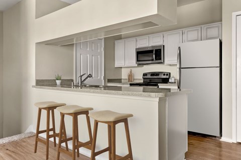 A kitchen with white cabinets and a white refrigerator.