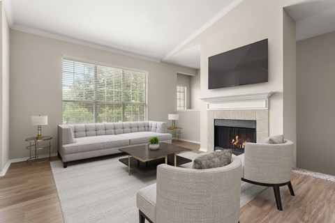 A modern living room with a grey sofa, a fireplace, and a television mounted above it.