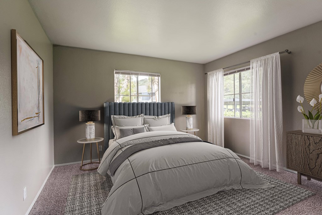 a bedroom with a bed and two windows