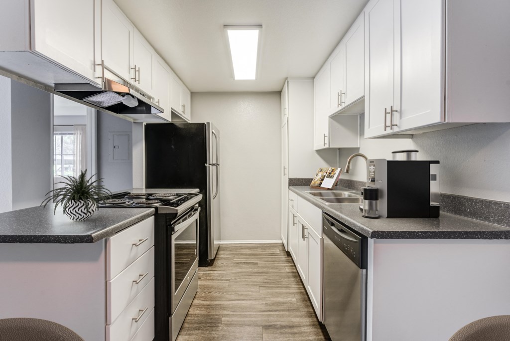 a kitchen with white cabinets and stainless steel appliances