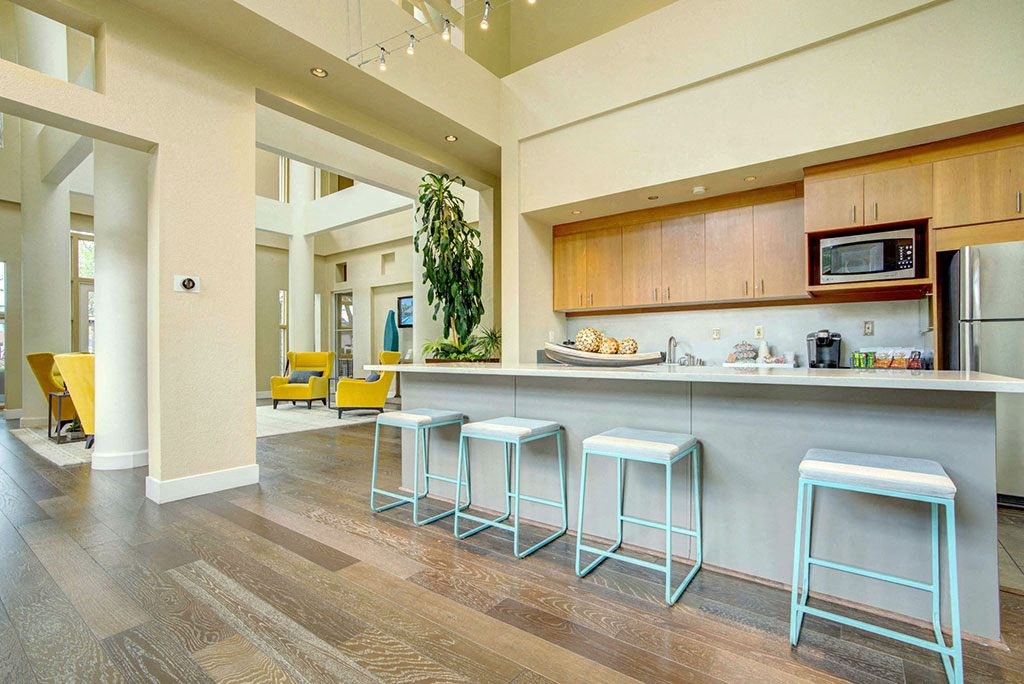 a kitchen with bar stools in front of a counter