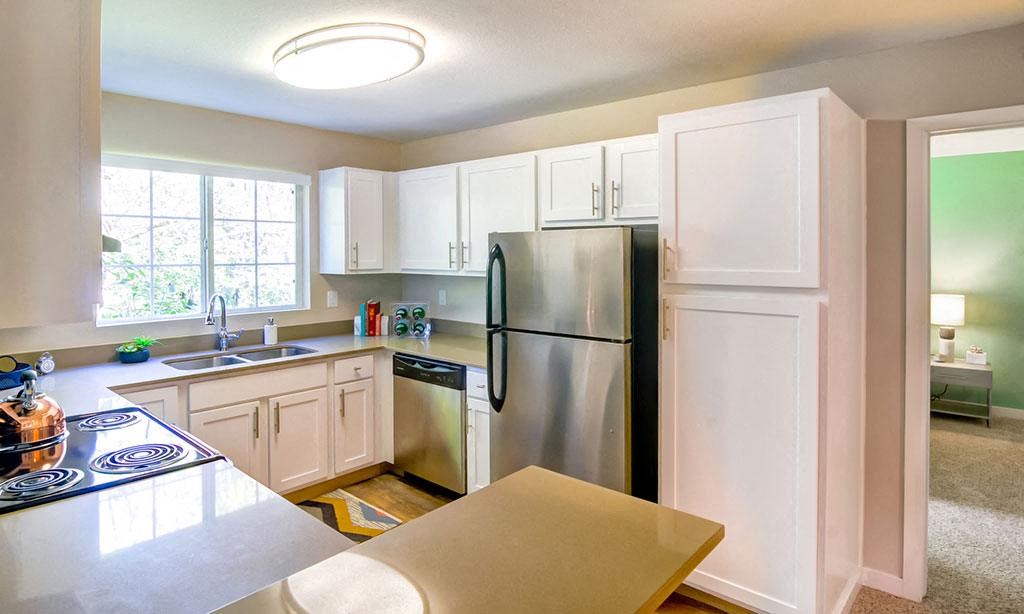 a kitchen with white cabinets and a stainless steel refrigerator