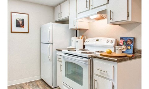 a kitchen with white appliances and a white refrigerator
