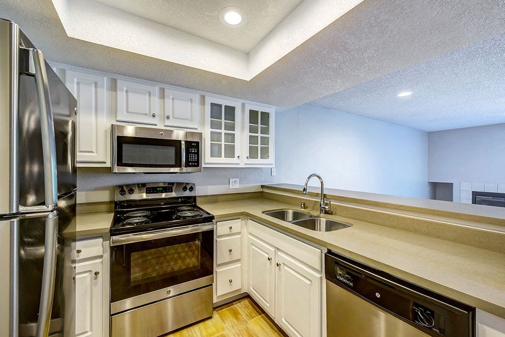 a kitchen with stainless steel appliances and white cabinets