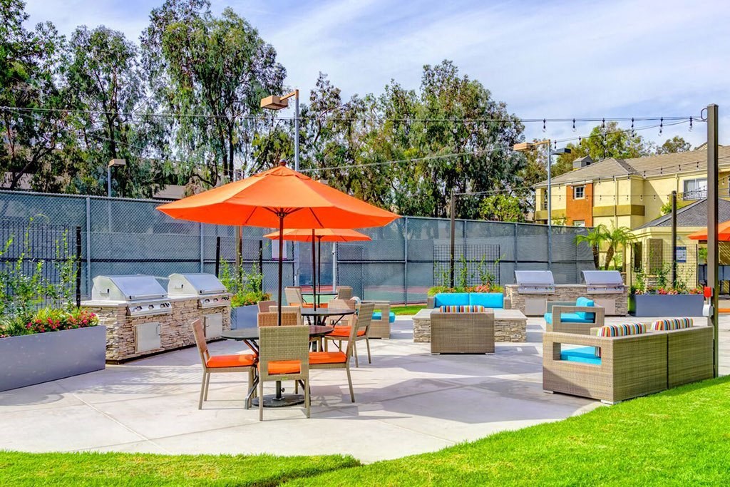 a patio with orange umbrellas and tables and chairs