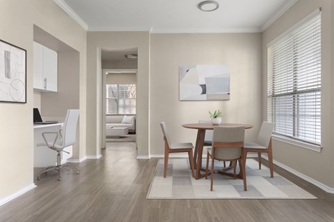 A dining room with a table and chairs.