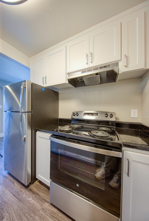 A kitchen with a stainless steel refrigerator and stove.