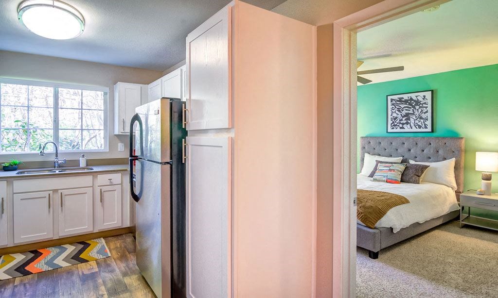 a bedroom with a bed and a refrigerator
