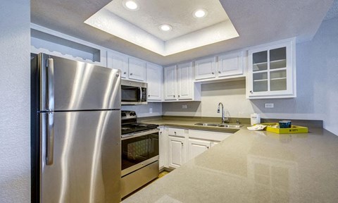 a kitchen with stainless steel appliances and white cabinets