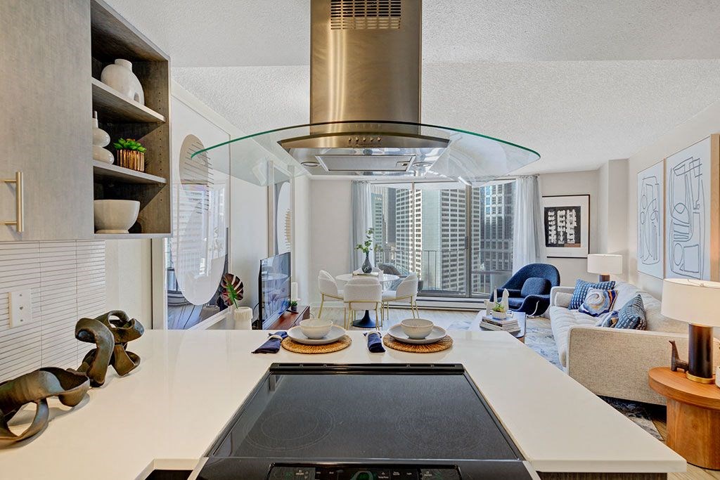 a kitchen with a stove and a view of a living room