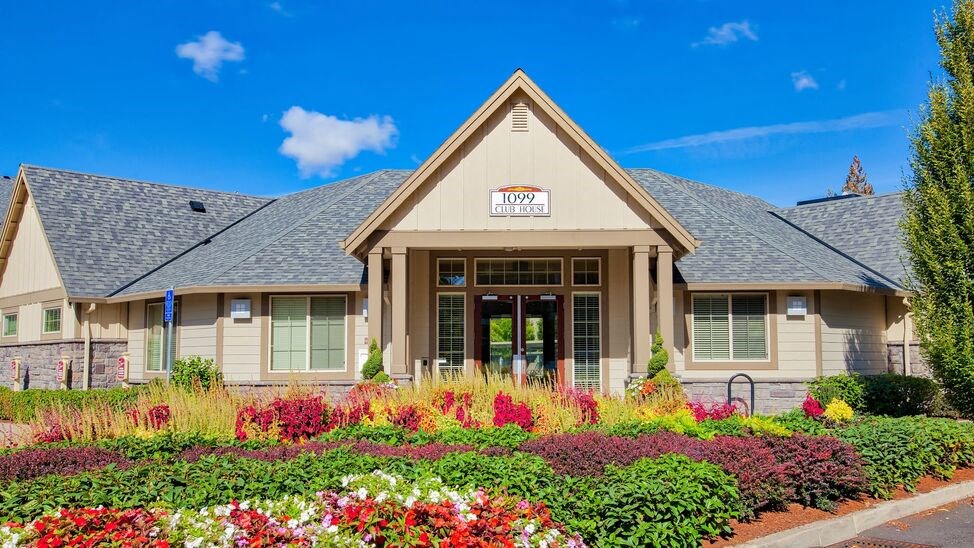 the front of a building with a flower garden in front of it