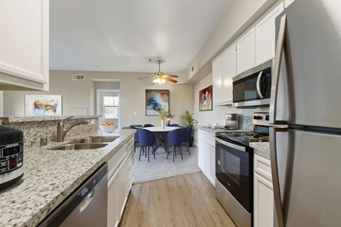 A kitchen with a table and chairs in the middle.