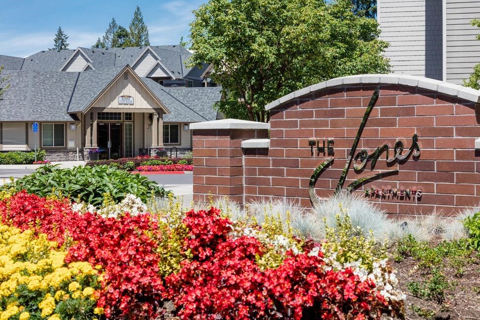 a building with a sign and flowers in front of it