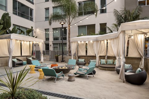 A patio area with a white canopy and blue chairs.