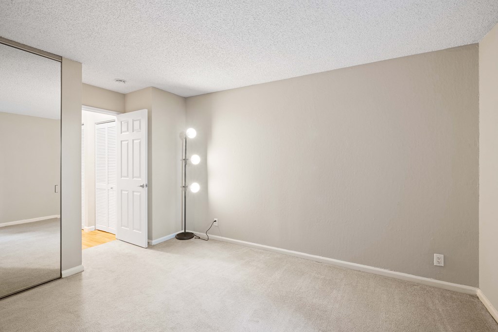 the spacious living room and dining room of an empty apartment