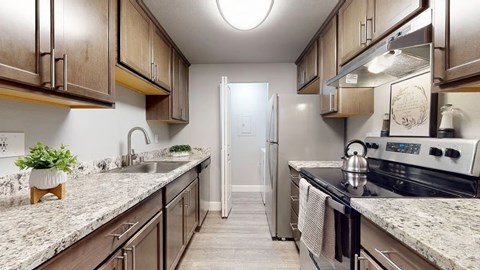 A kitchen with wooden cabinets and granite countertops.