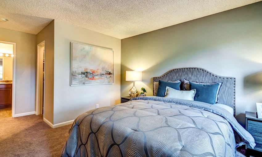 a bedroom with a large bed and a door to a bathroom