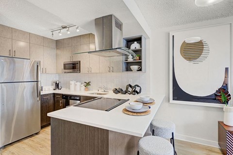 a kitchen with a island and a stainless steel refrigerator