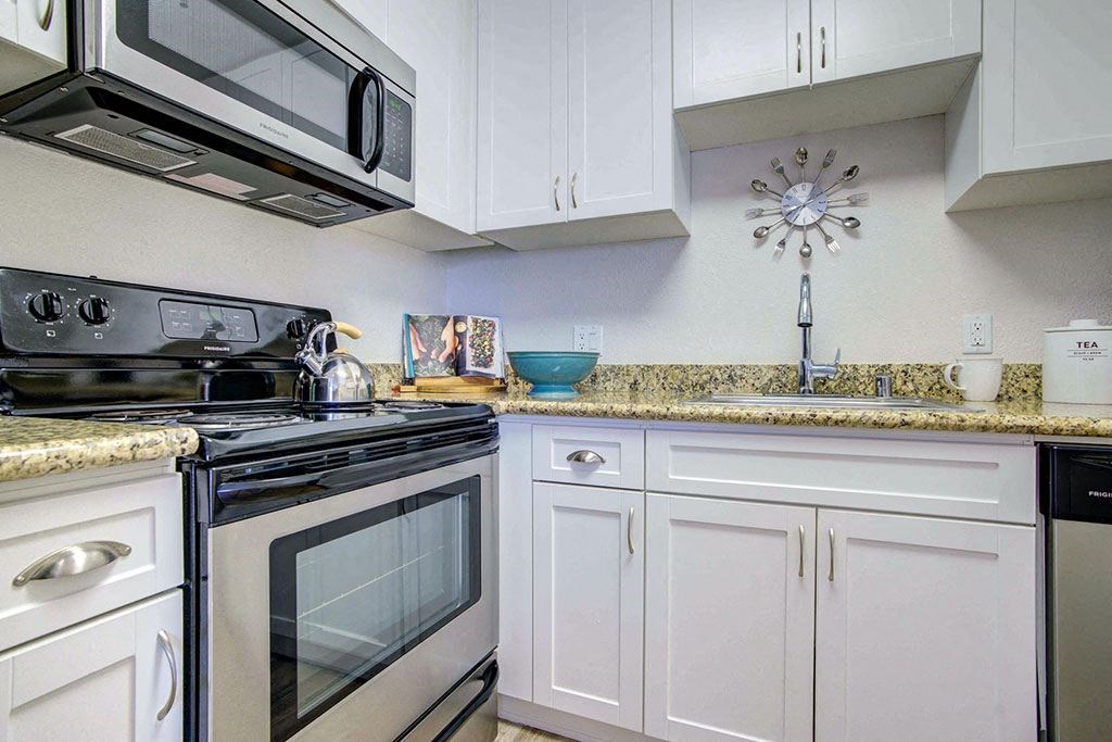 a kitchen with a stove and a sink and a microwave
