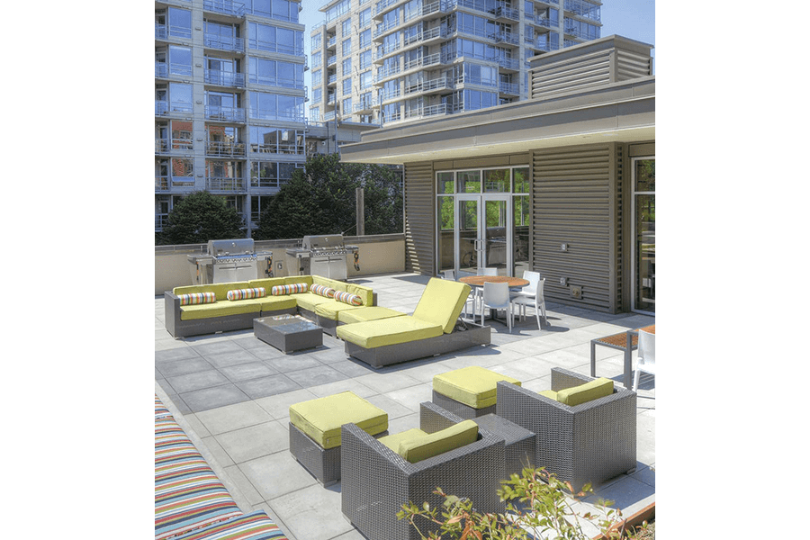 a large patio with furniture and a building in the background
