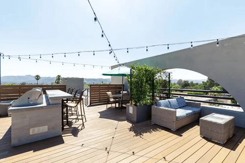 A patio with a hot tub and chairs.