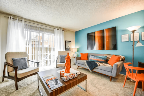 A living room with a blue wall and a coffee table in the center.